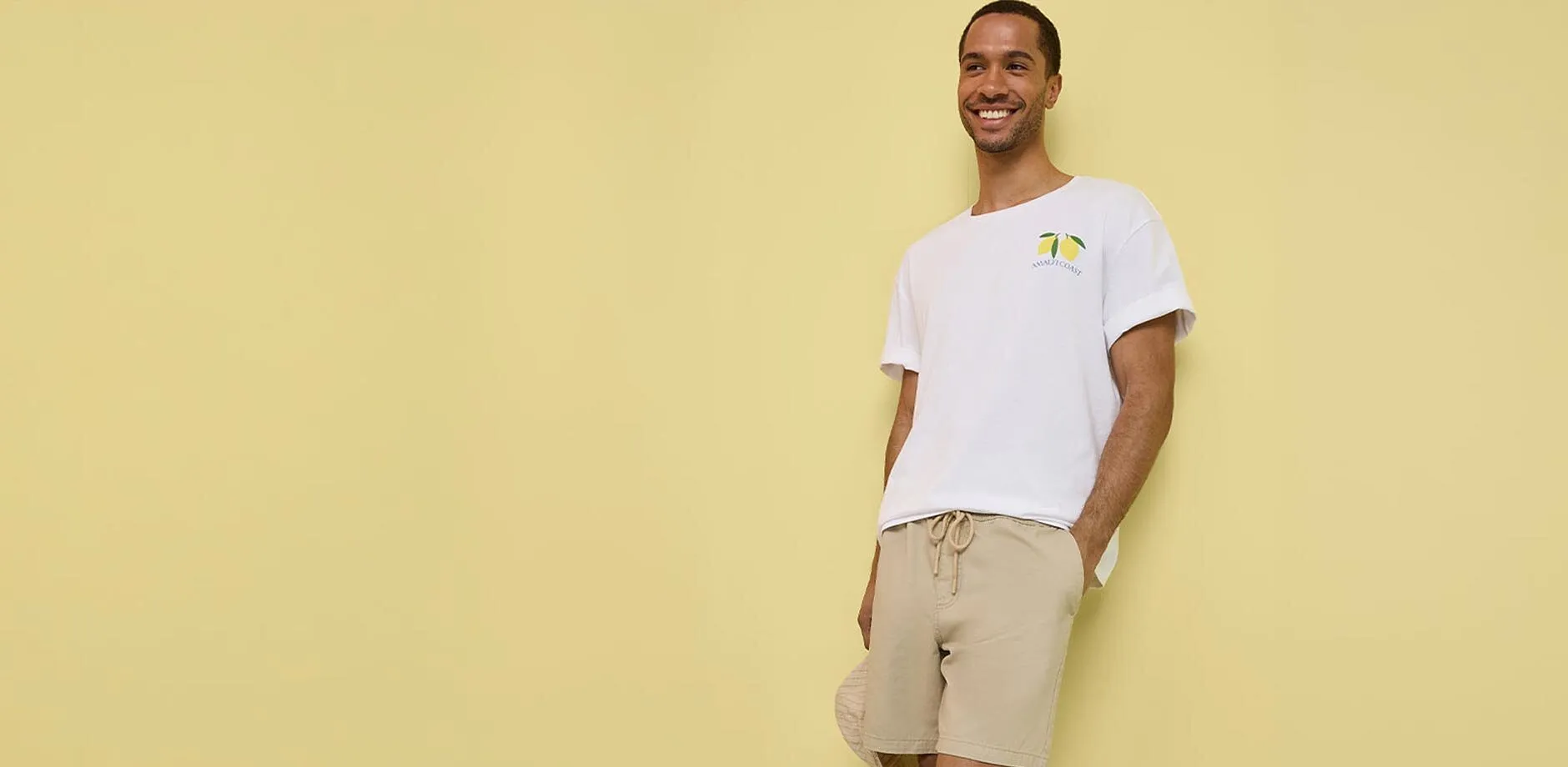 L&auml;ssiges Outfit mit wei&szlig;em T-Shirt, beigefarbenen Shorts und wei&szlig;en Sneakern.