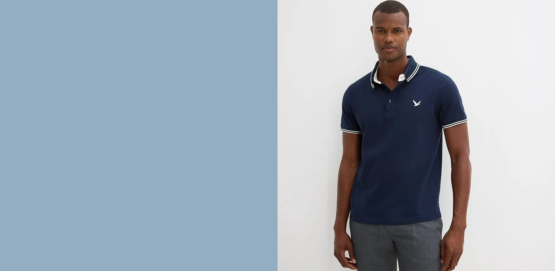 Elegantes dunkelblaues Poloshirt mit wei&szlig;en Kontraststreifen und grauer Hose f&uuml;r den modernen Mann.