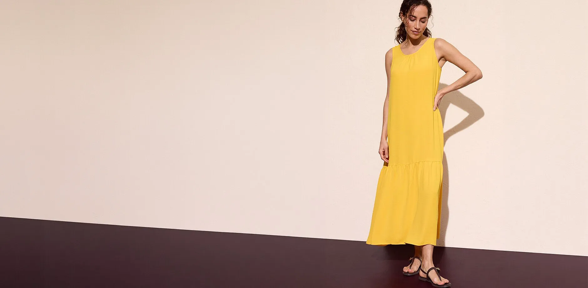 Robe longue jaune sans manches associ&eacute;e &agrave; des sandales noires.