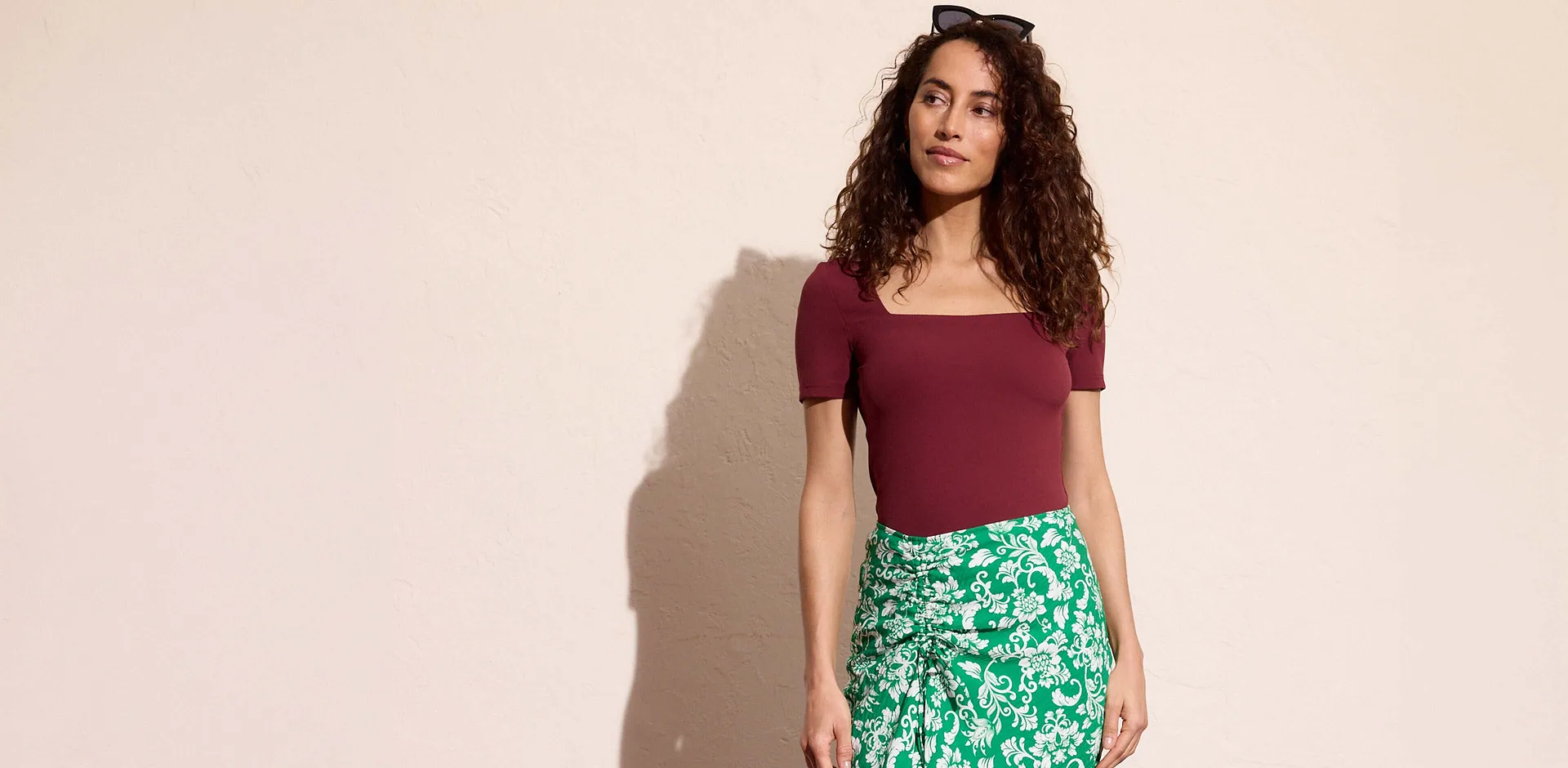 T-shirt rouge bourgogne associ&eacute; &agrave; une jupe &agrave; imprim&eacute; fleurs vert et blanc.