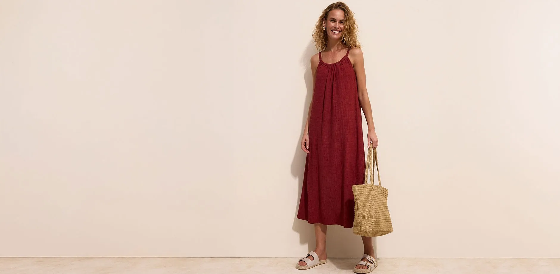 Robe longue rouge, sandales confortables et un sac en paille.