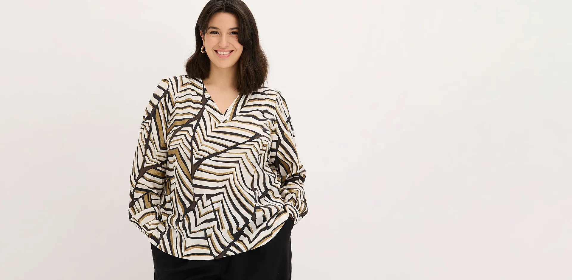 Blouse &agrave; motif graphique et pantalon noir.