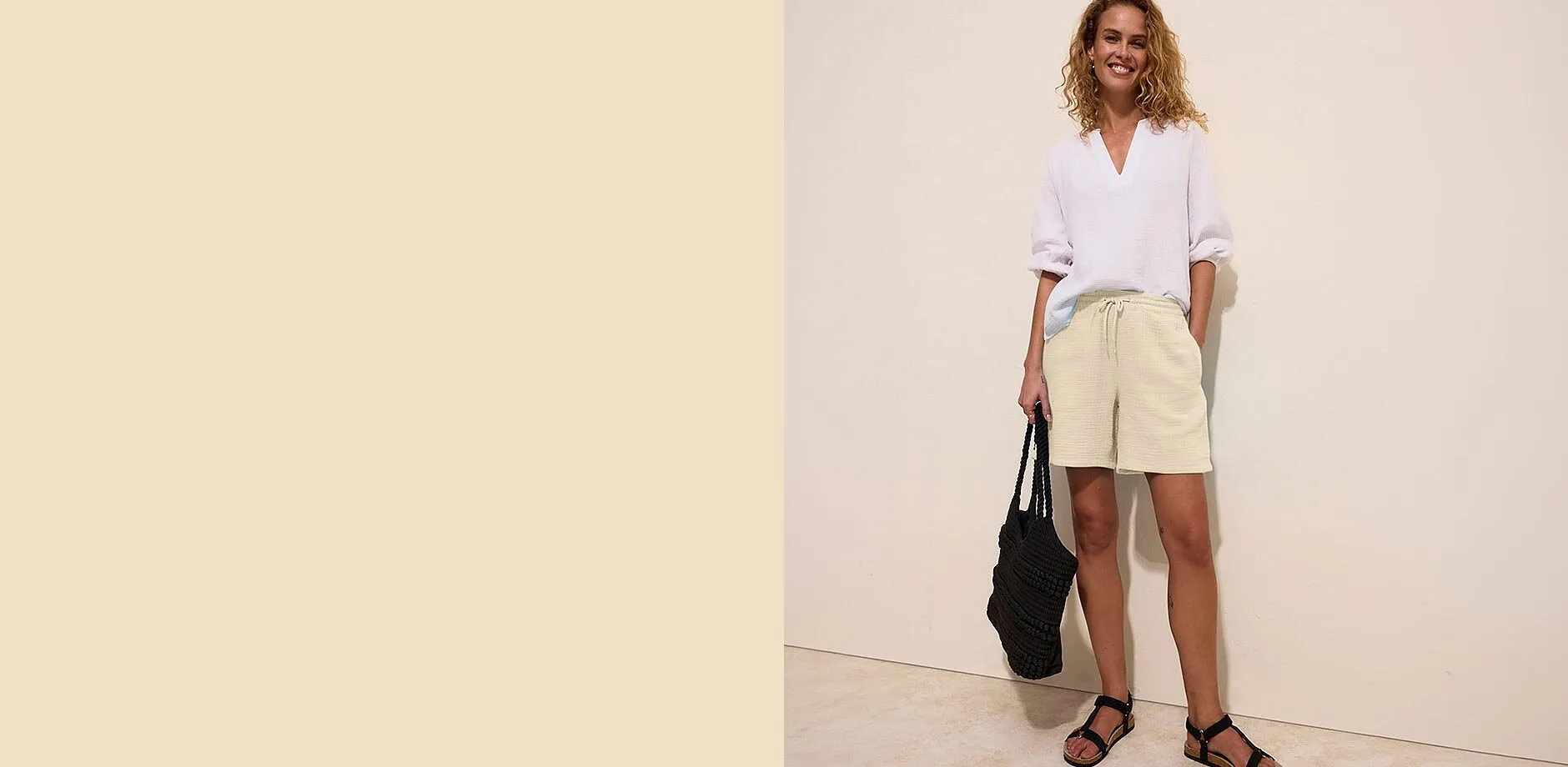 Wei&szlig;e Bluse, beige Musselin-Shorts und schwarze Sandalen f&uuml;r einen l&auml;ssigen Sommerlook.