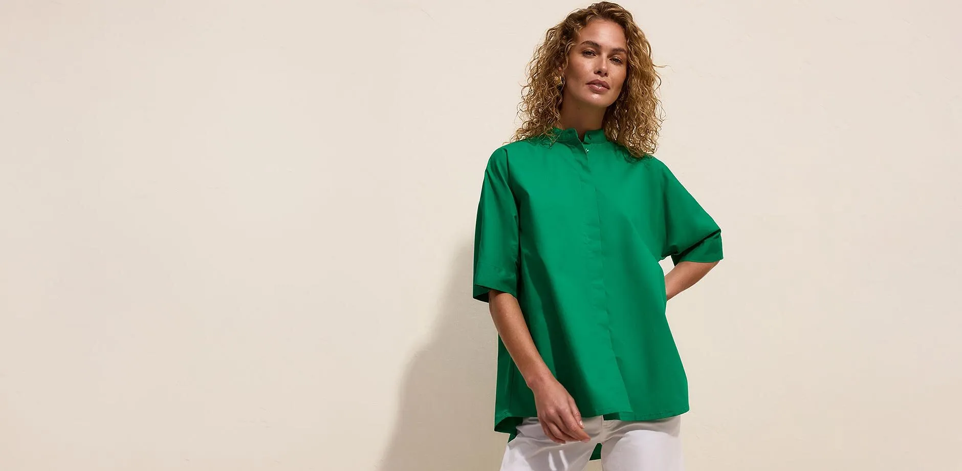 Blouse verte oversize avec col montant et manches courtes.