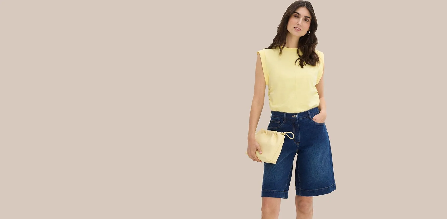 Top jaune &agrave; &eacute;paulettes, bermuda en jean bleu et sac boule assorti.