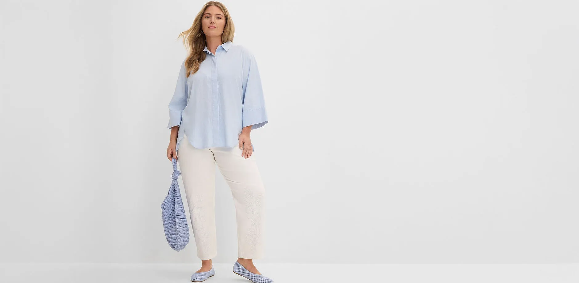 Chemise bleu clair, pantalon blanc, ballerines et sac assortis.