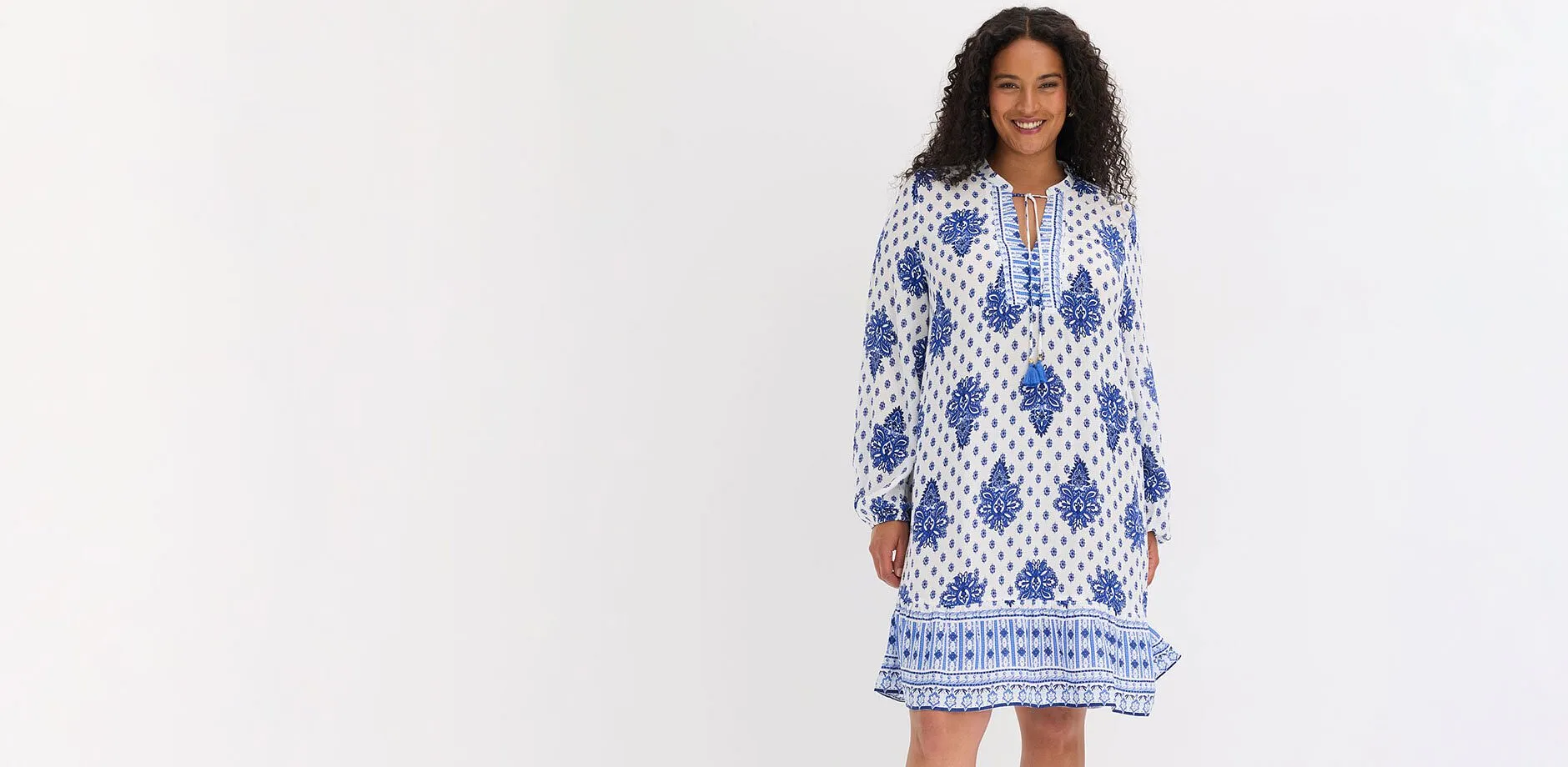 Robe-tunique dans des tons blanc et bleu &agrave; motif ethnique, liens &agrave; nouer et manches longues.