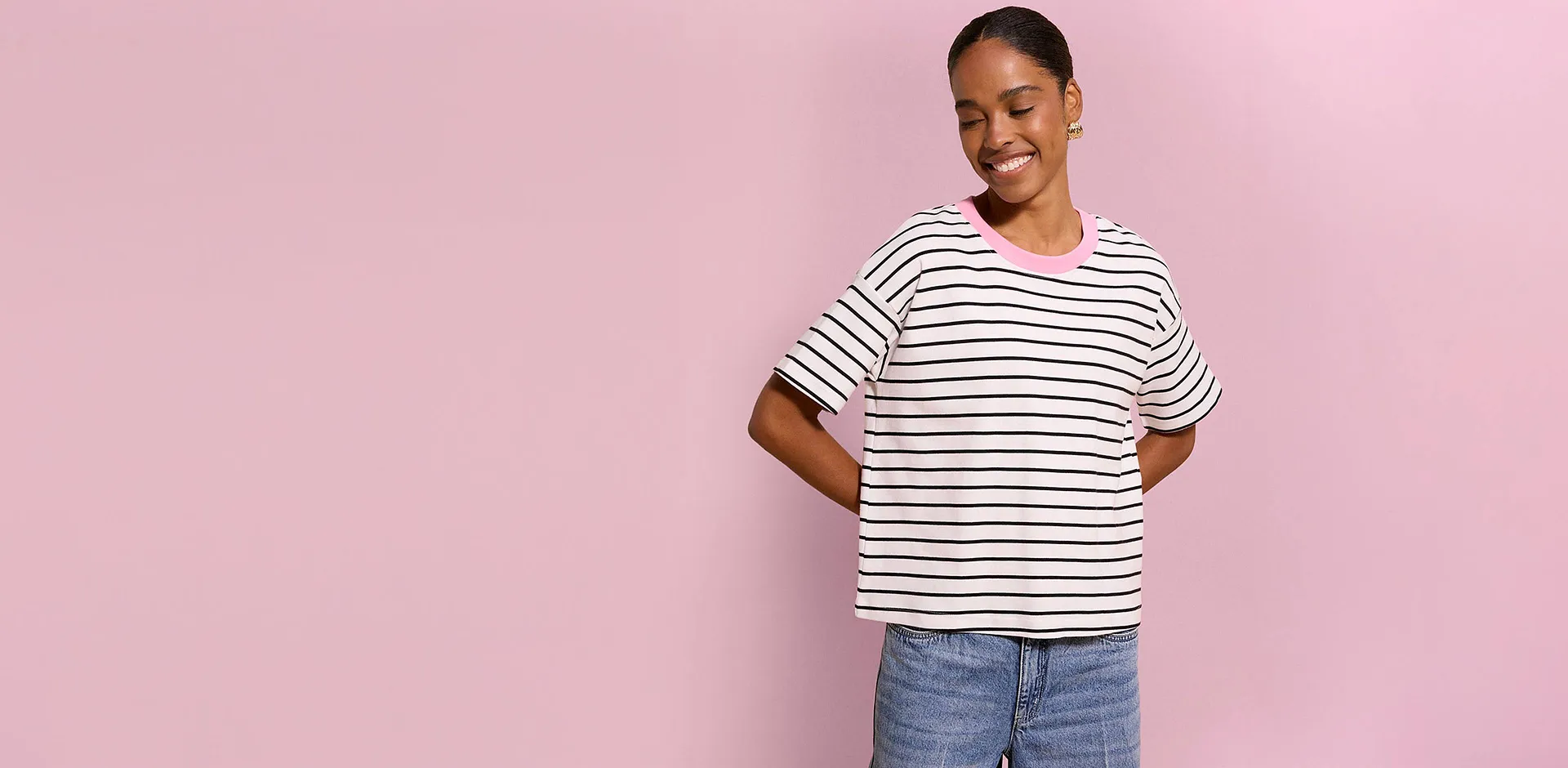 T-shirt d&eacute;contract&eacute; &agrave; rayures avec col rose et jean bleu.