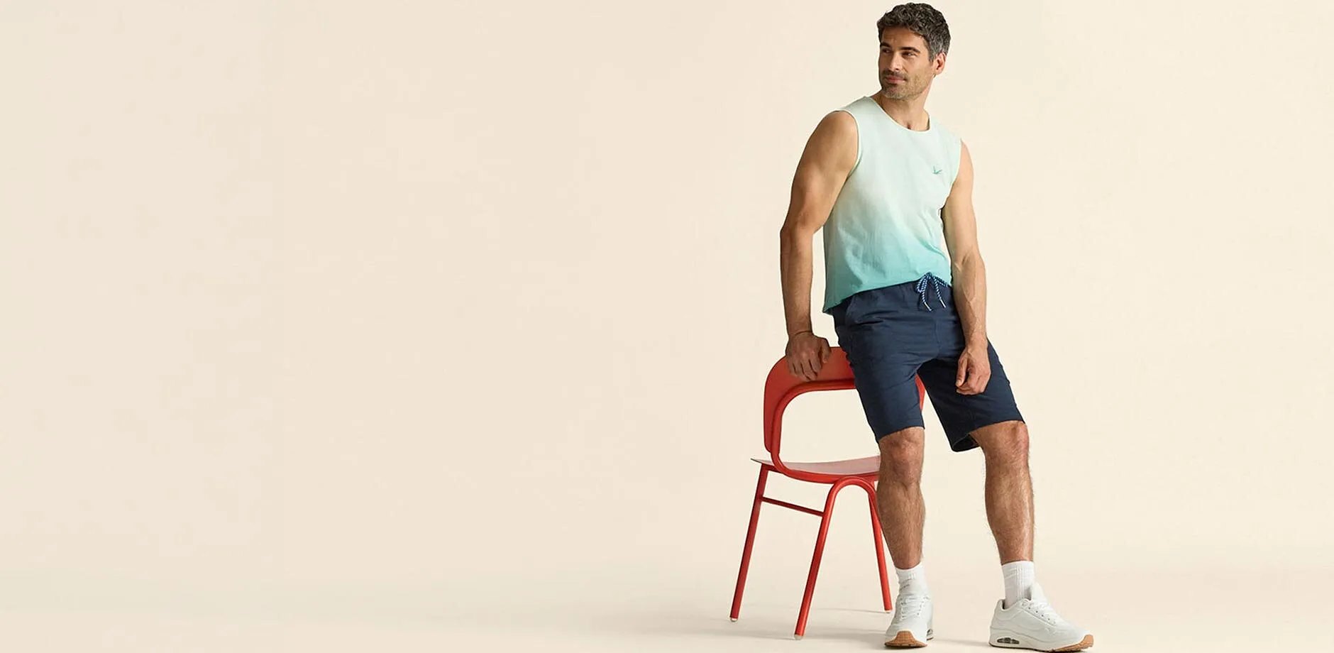 T-shirt tendance sans manches avec d&eacute;grad&eacute; de couleur, short bleu et baskets blanches.