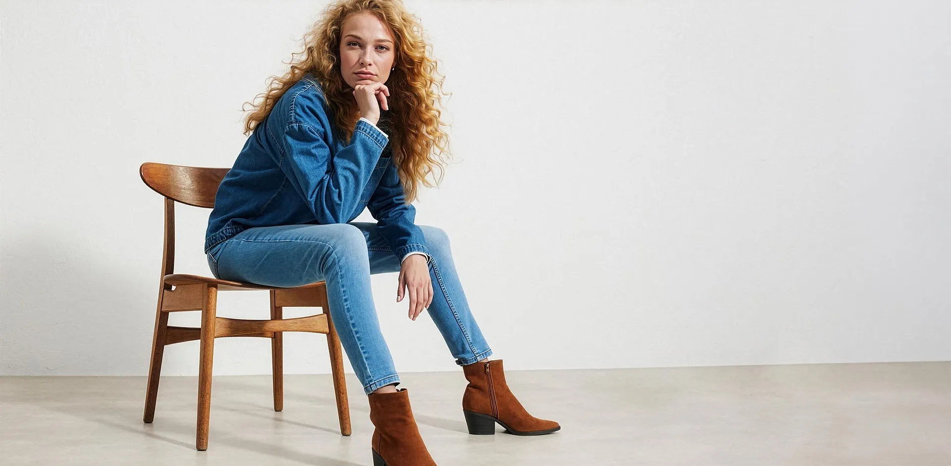 Femme portant une veste en jean bleue, un jean et des bottines marron styl&eacute;es.