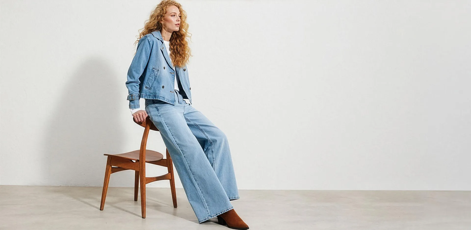 Veste en jean courte bleu clair, pantalon large et T-shirt blanc.