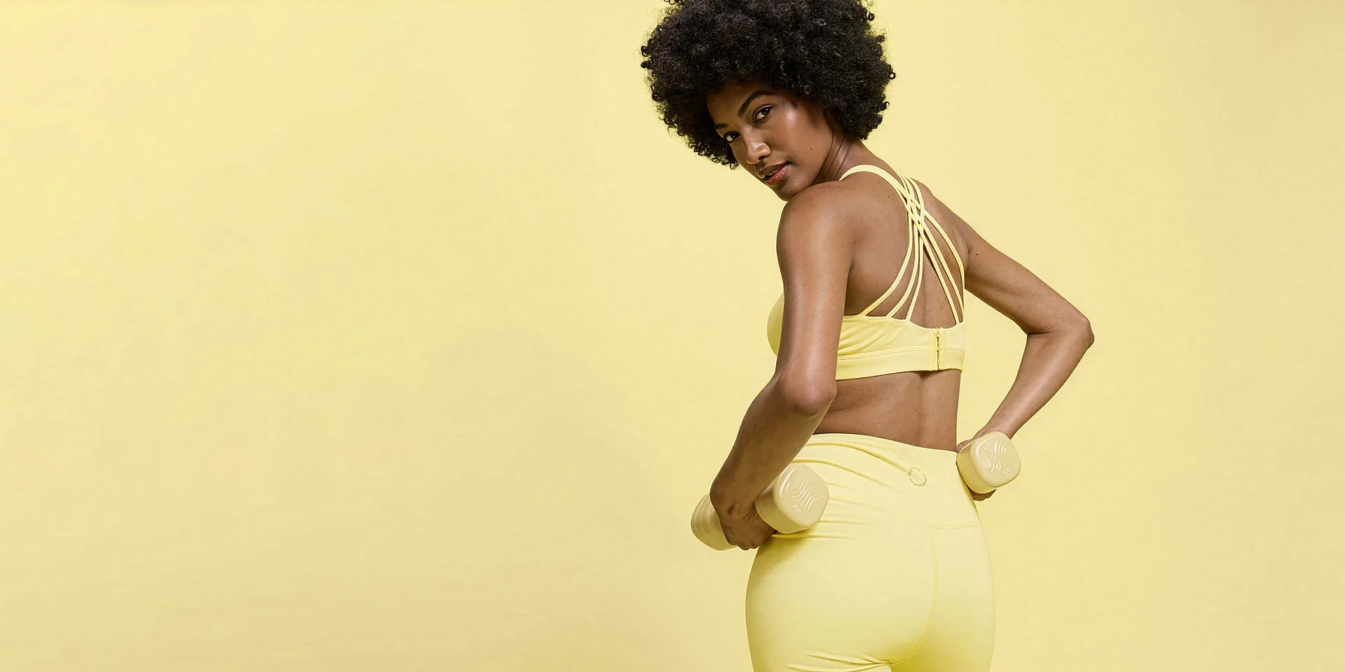 Tenue de sport jaune : soutien-gorge avec bretelles crois&eacute;es dans le dos et legging assorti.