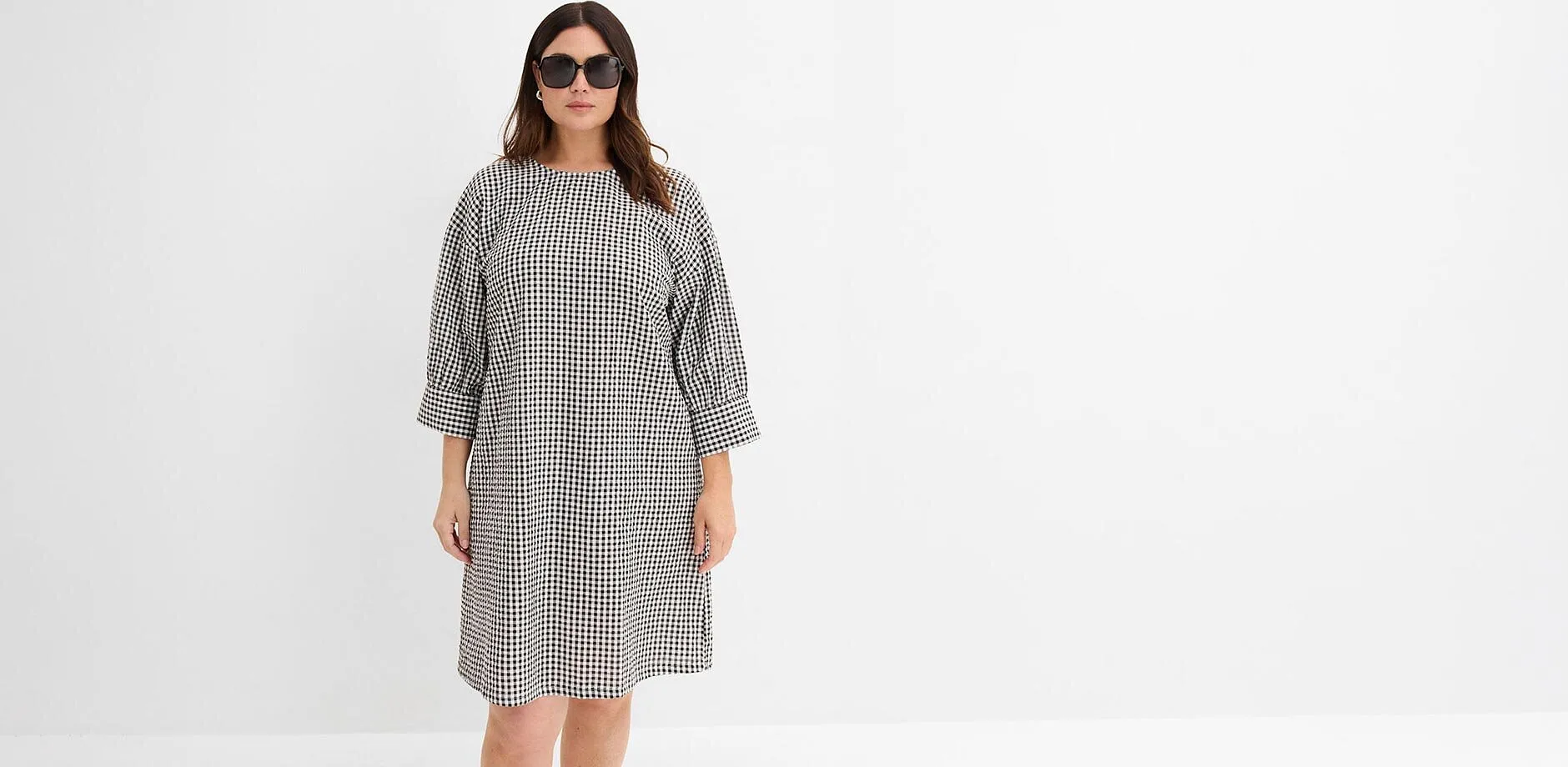 Robe &agrave; carreaux noir et blanc, coupe ample et manches 3/4.
