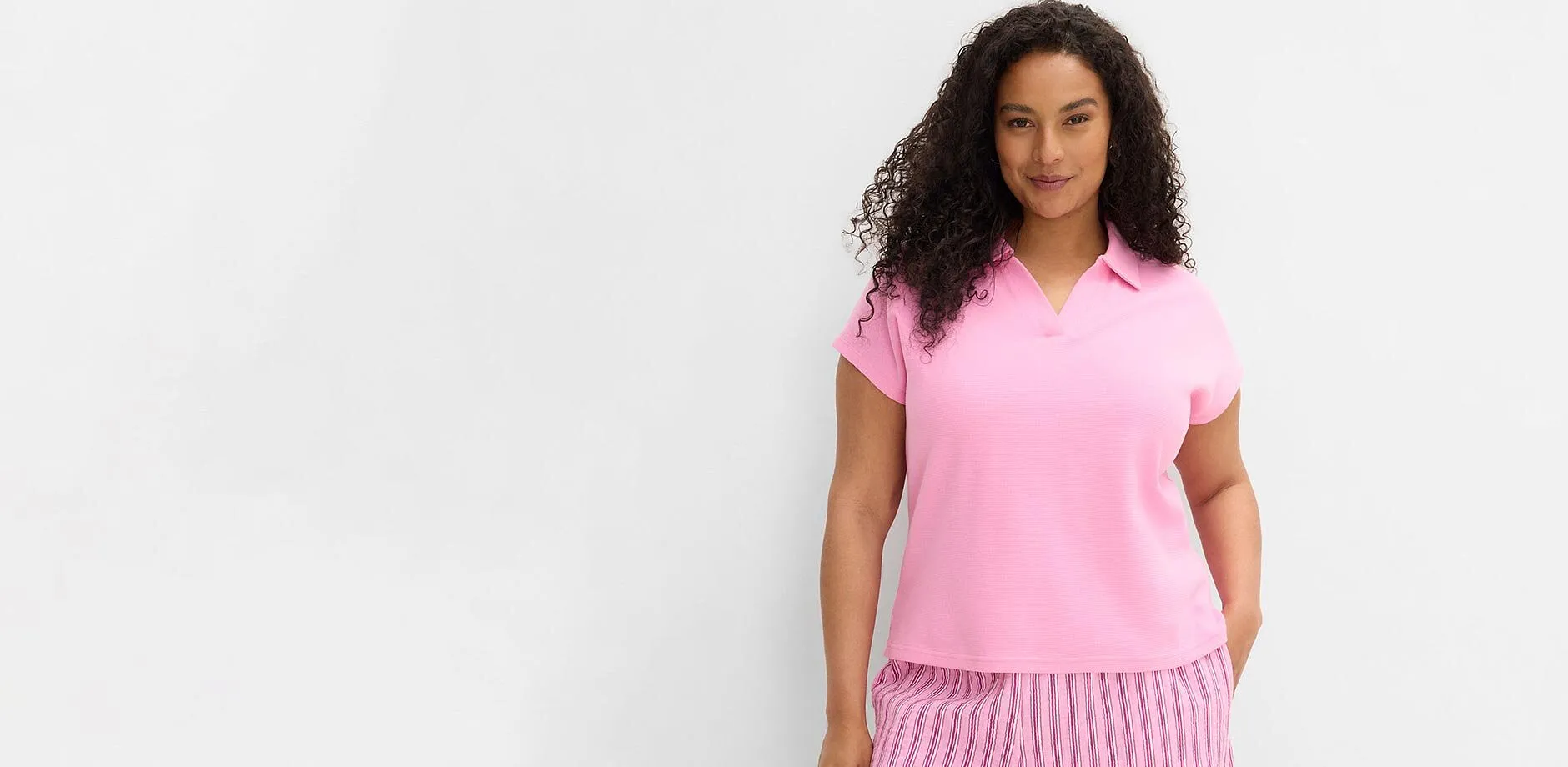 Polo rose &agrave; manches courtes et pantalon ray&eacute;.