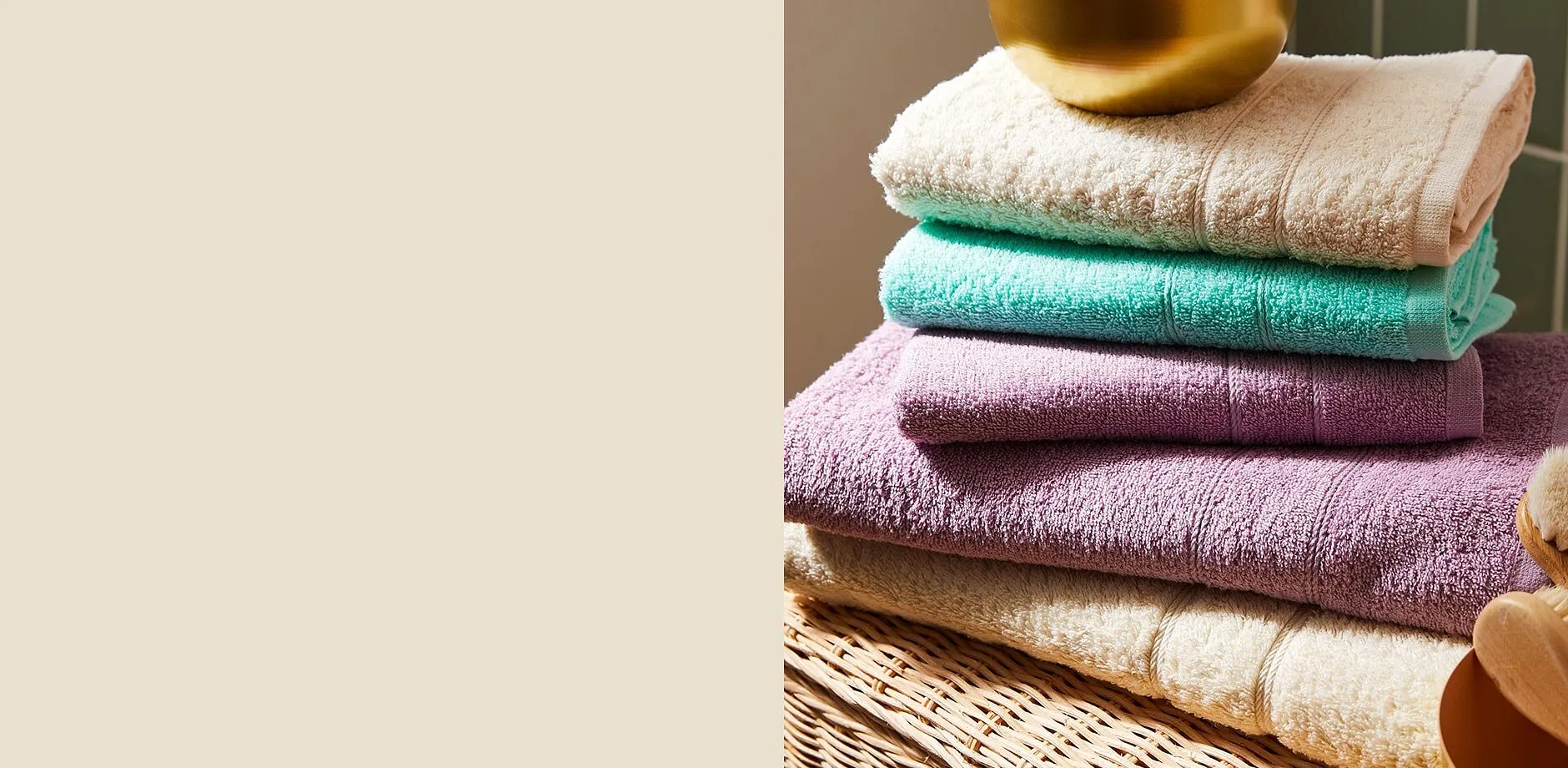 Serviettes de toilette moelleuses et color&eacute;es dans des tons cr&egrave;me, menthe et lilas, soigneusement empil&eacute;es.