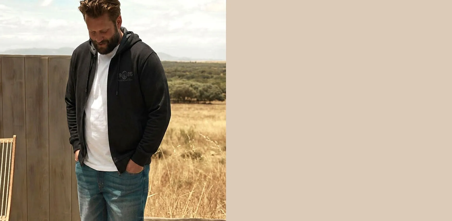 Dunkler Hoodie &uuml;ber wei&szlig;em T-Shirt, dazu blaue Jeans &ndash; bequemer Stil.