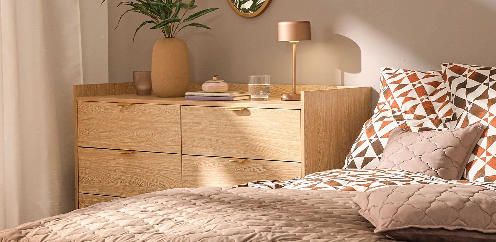 Parure de lit imprim&eacute;e dans des tons orange et marron, rehauss&eacute;e d'une couverture matelass&eacute;e et de coussins d&eacute;co.