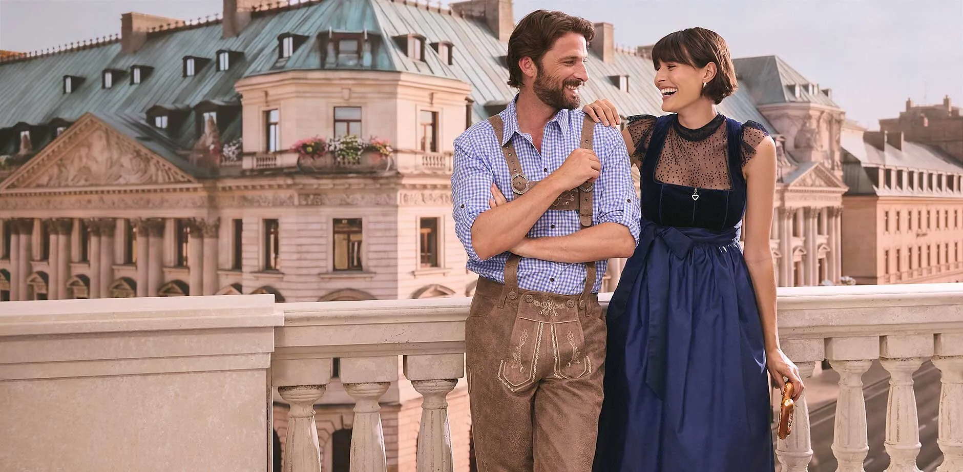 Elegantes dunkelblaues Dirndl trifft auf klassische Lederhosen und kariertes Hemd.