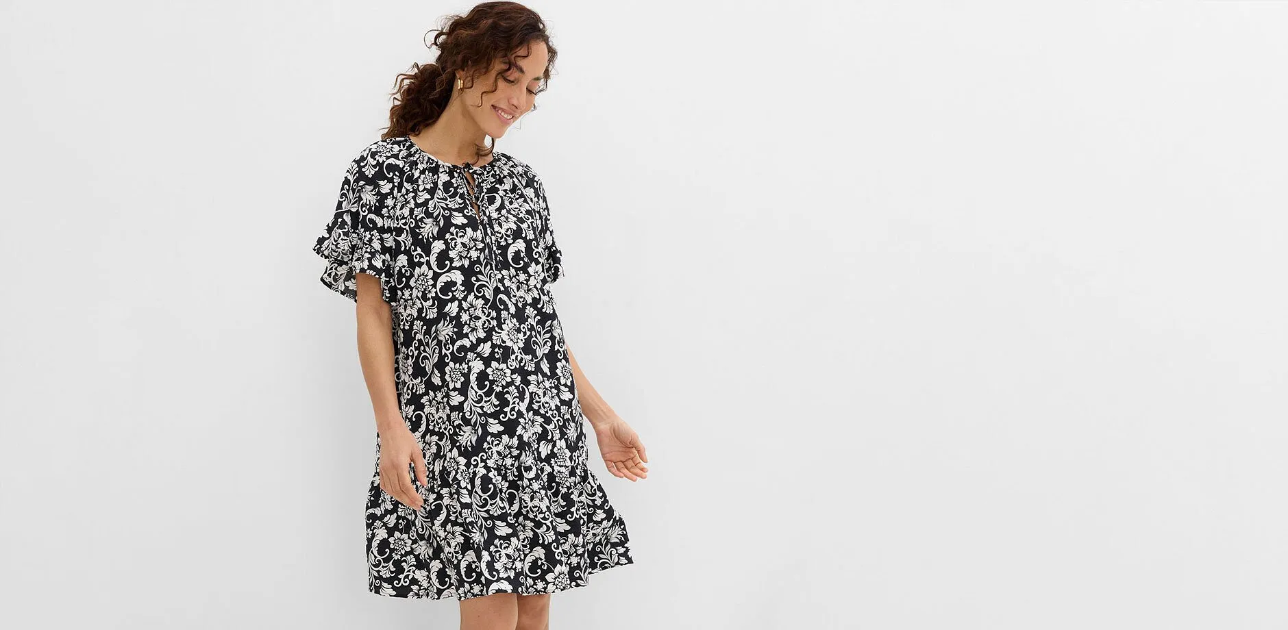 Robe ample &agrave; motif floral en noir et blanc avec manches &agrave; volants &eacute;l&eacute;gantes.