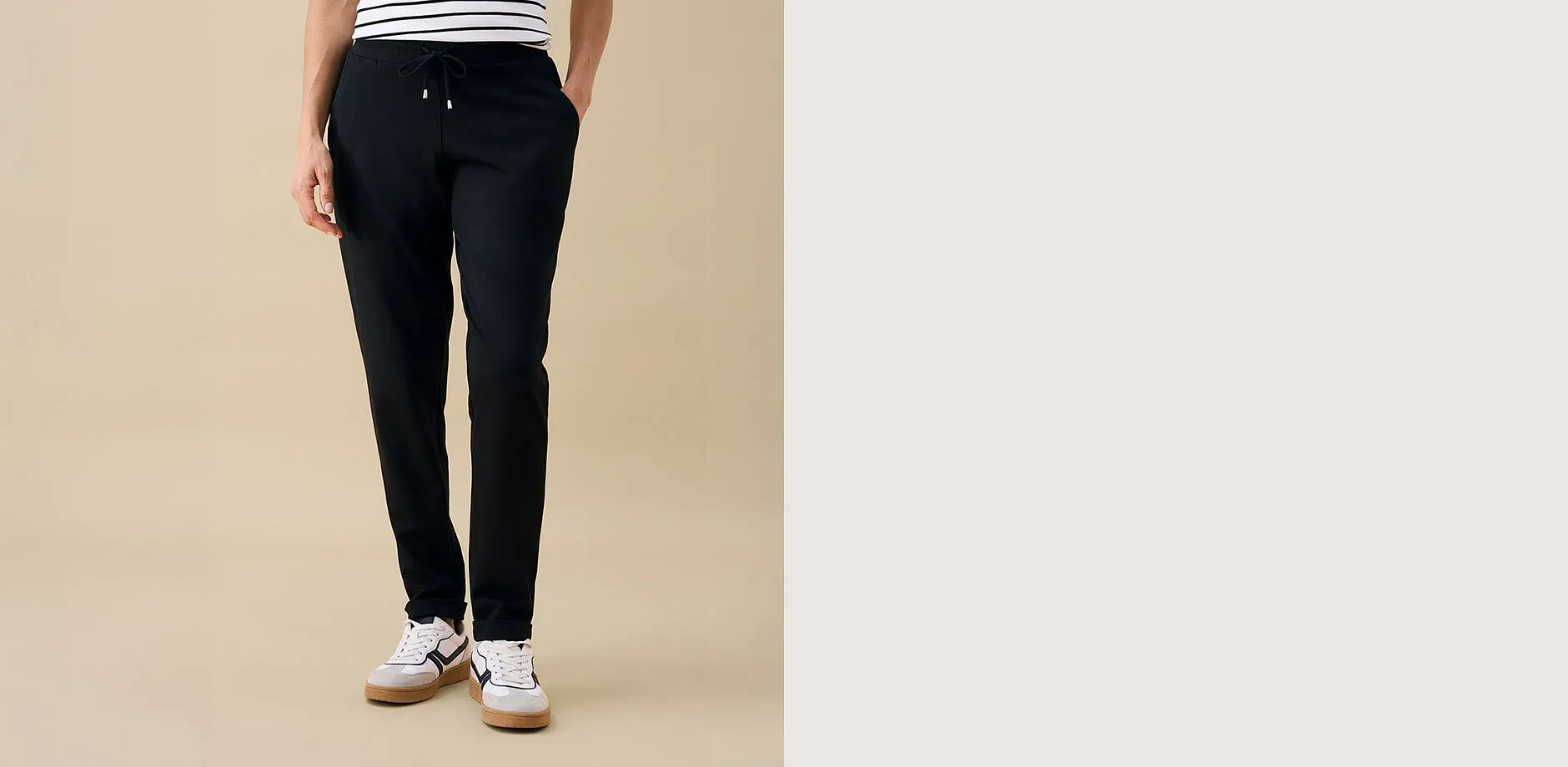 Schwarze Hose, gestreiftes Shirt und moderne Sneaker &ndash; ein komfortabler Casual-Look.