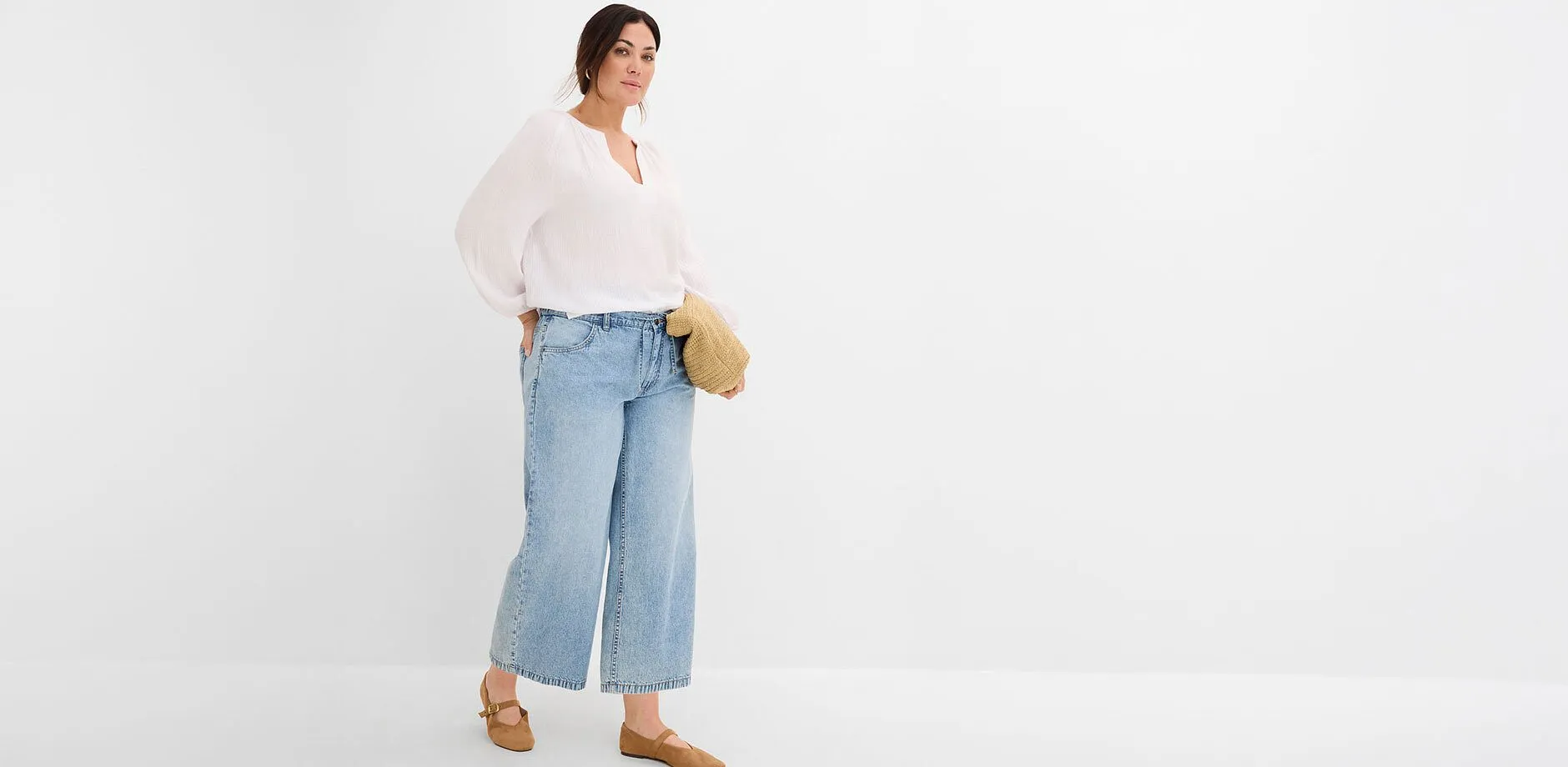 Blouse blanche ample, jean large, chaussures marron et petit sac tress&eacute;.