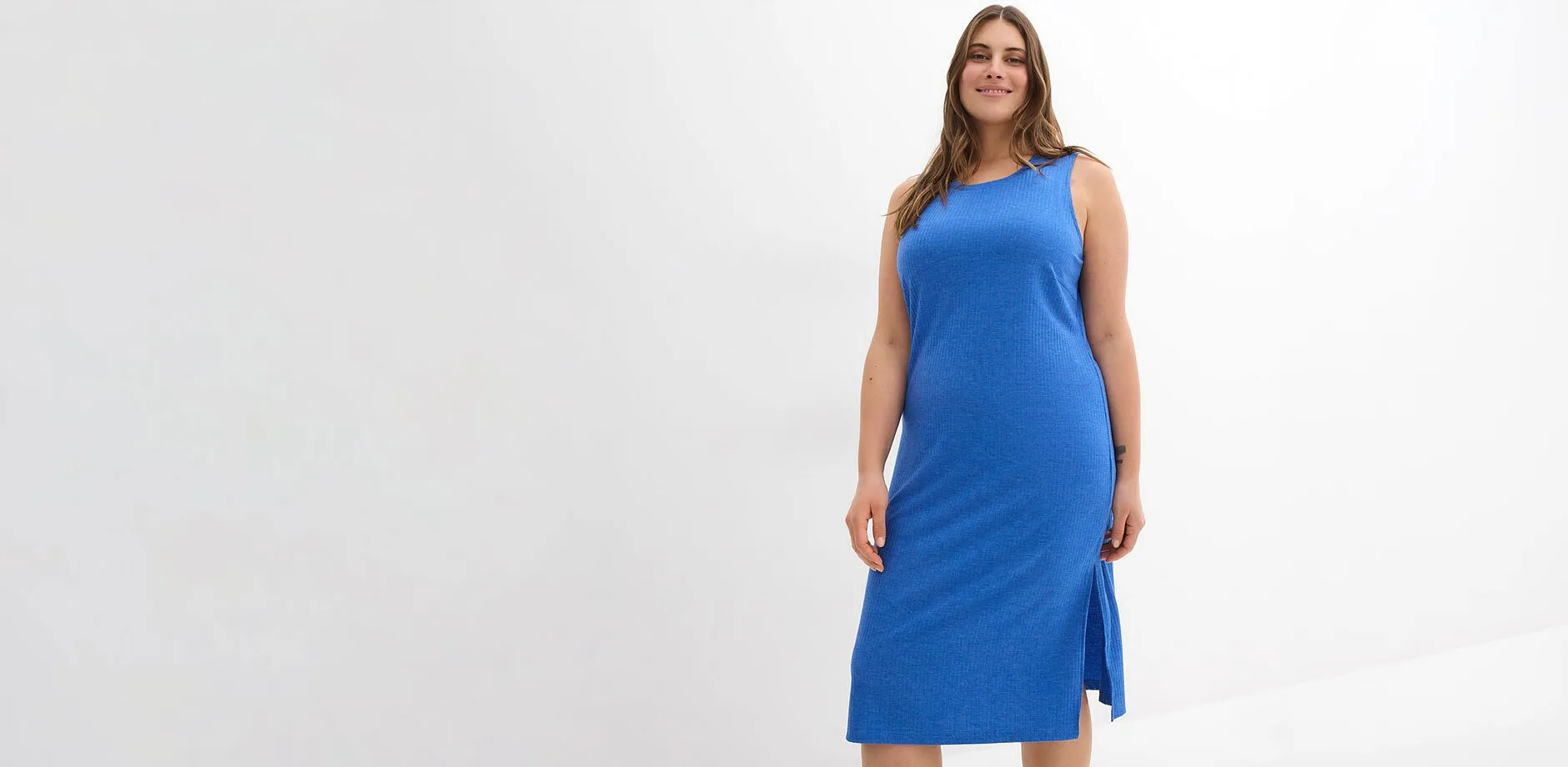 Femme v&ecirc;tue d'une robe midi c&ocirc;tel&eacute;e sans manches avec fentes lat&eacute;rales de couleur bleue.
