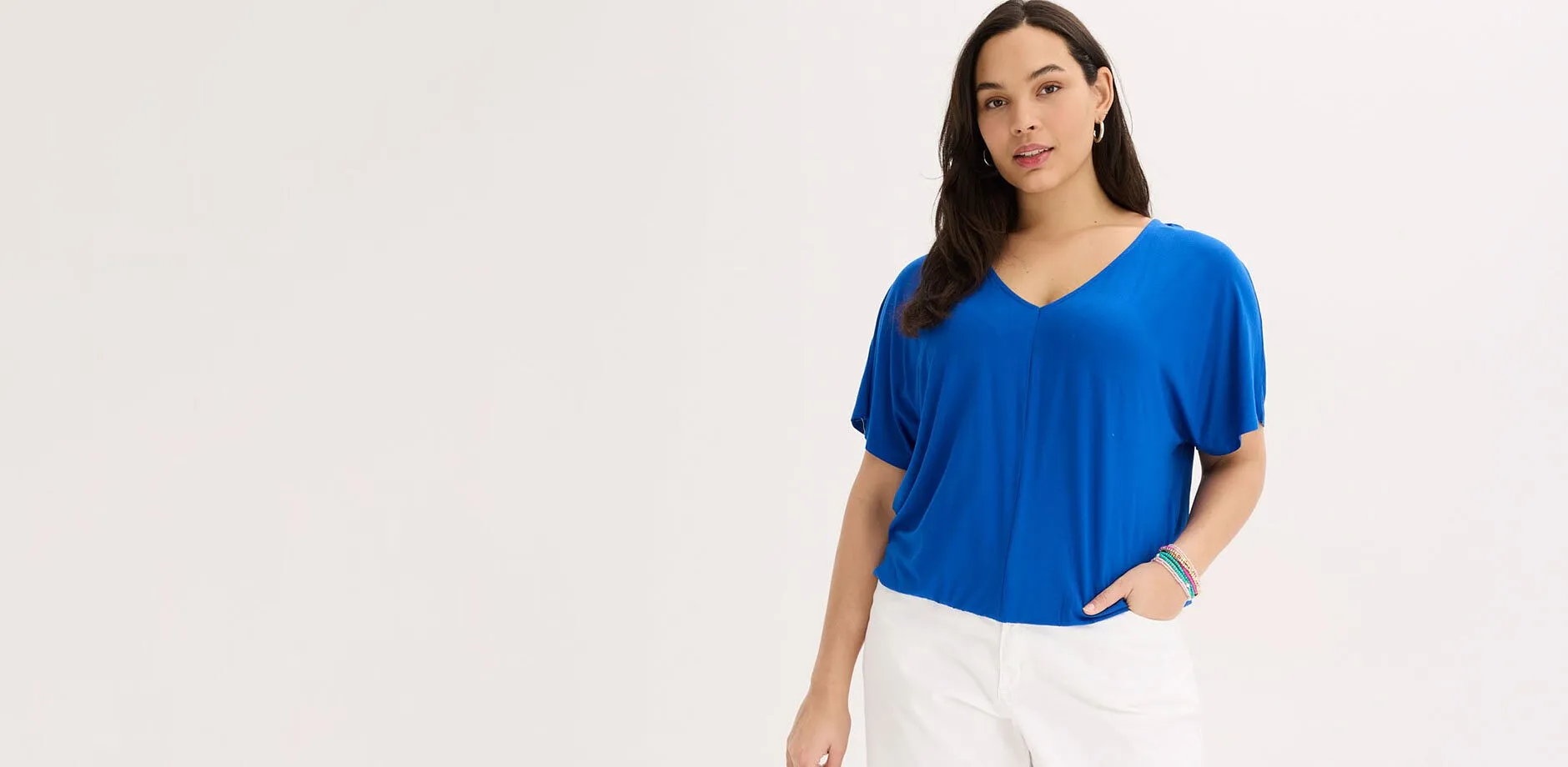 T-shirt bleu oversize avec d&eacute;collet&eacute; en V et pantalon blanc.