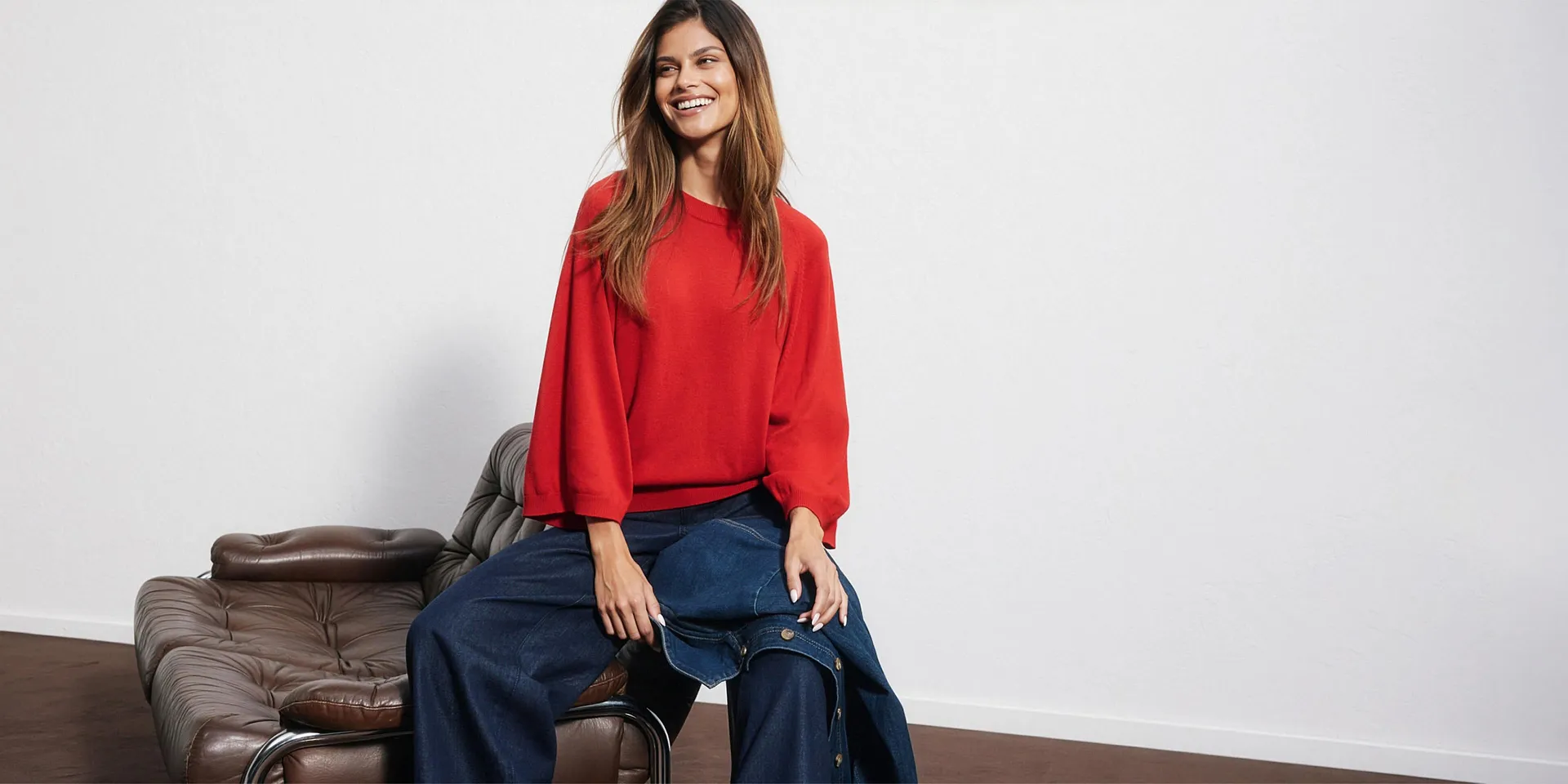 Pull rouge, jean large et veste en jean assortie.