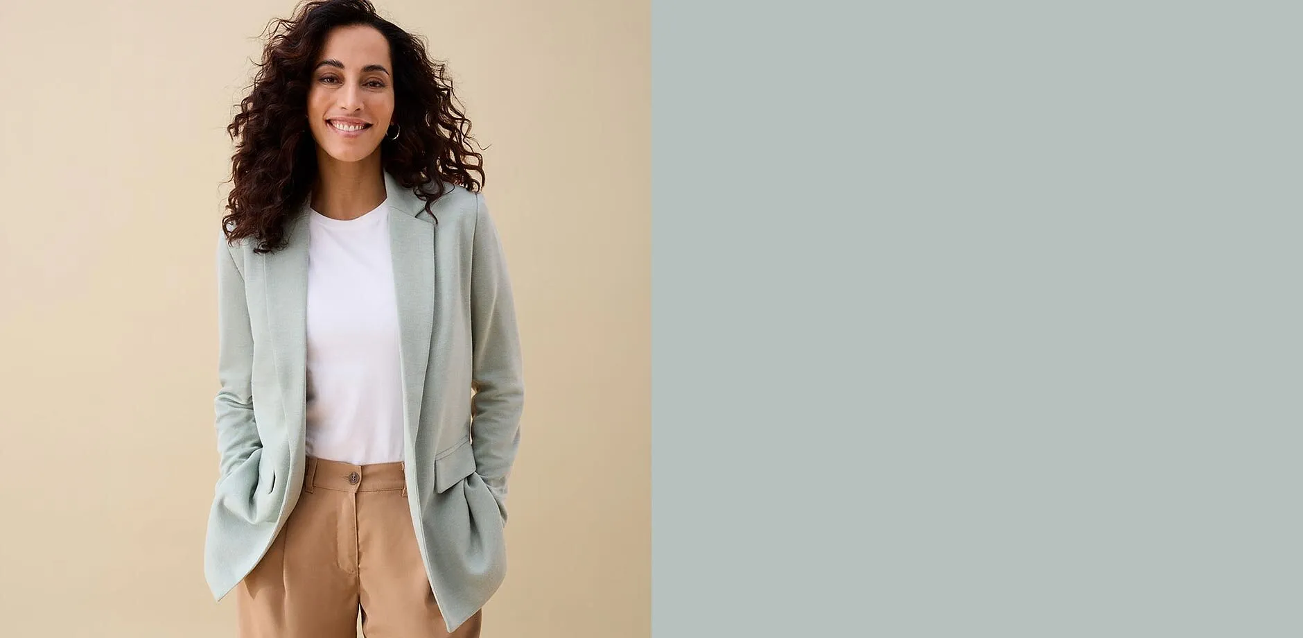 Femme v&ecirc;tue d'un blazer vert menthe, un T-shirt blanc et un pantalon marron.