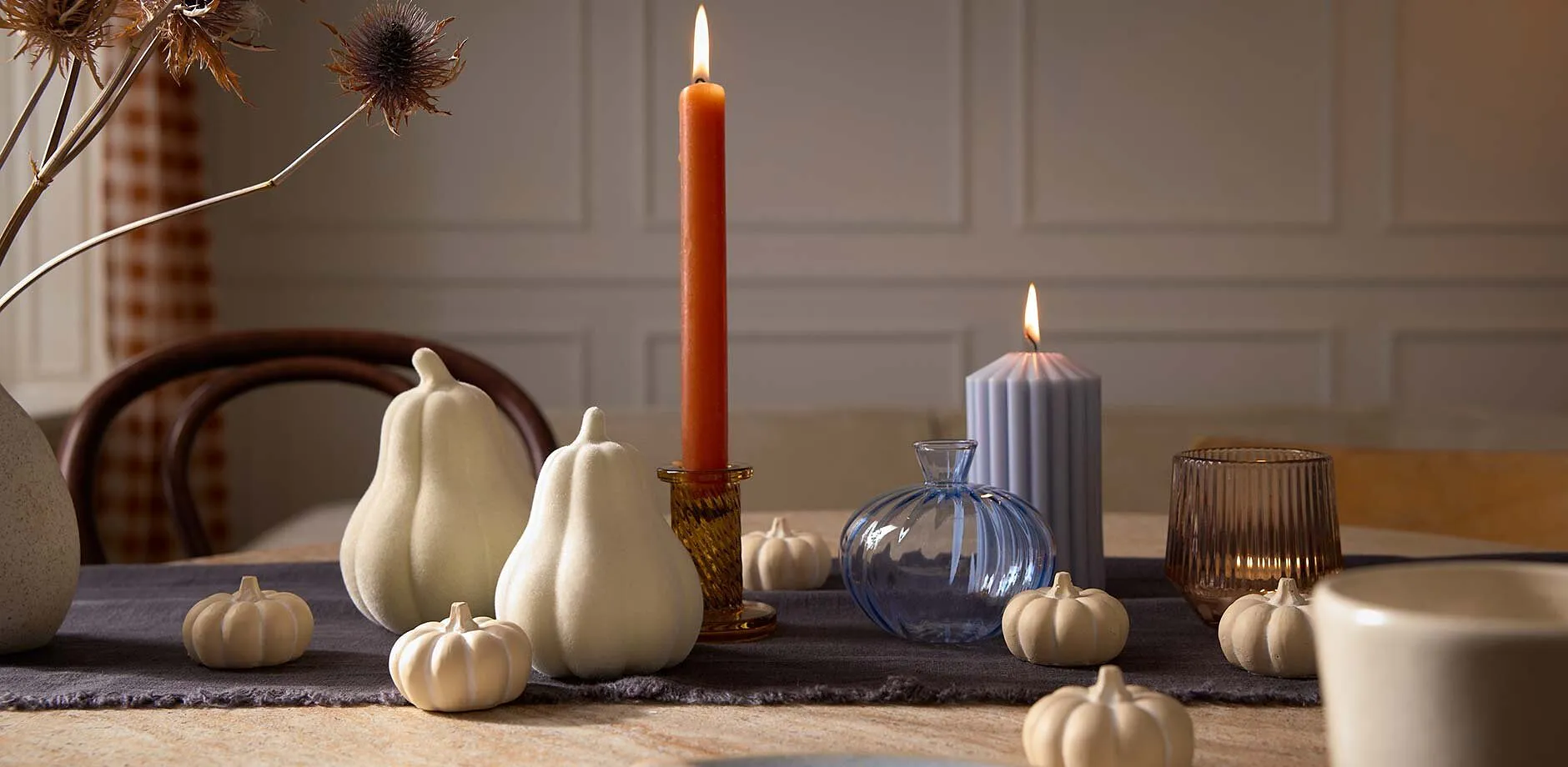 D&eacute;coration automnale avec des citrouilles blanches et une bougie.