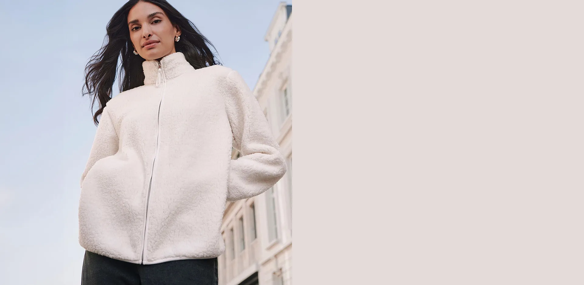 Flauschige, cremefarbene Teddyfell-Jacke mit Rei&szlig;verschluss und modischer dunkler Hose.