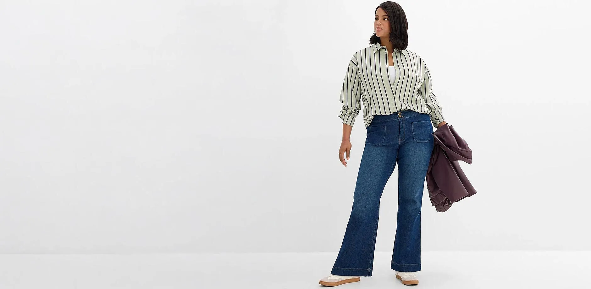 Tenue d&eacute;contract&eacute;e : chemise &agrave; rayures, jean &eacute;vas&eacute; bleu et veste moderne.