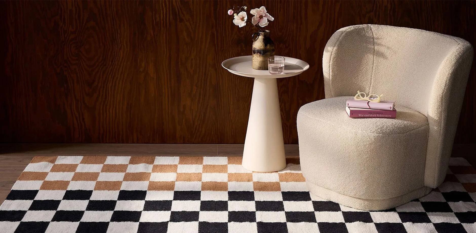 Pi&egrave;ce &agrave; l'ambiance &eacute;l&eacute;gante avec tapis &agrave; carreaux, fauteuil douillet et table d'appoint minimaliste.