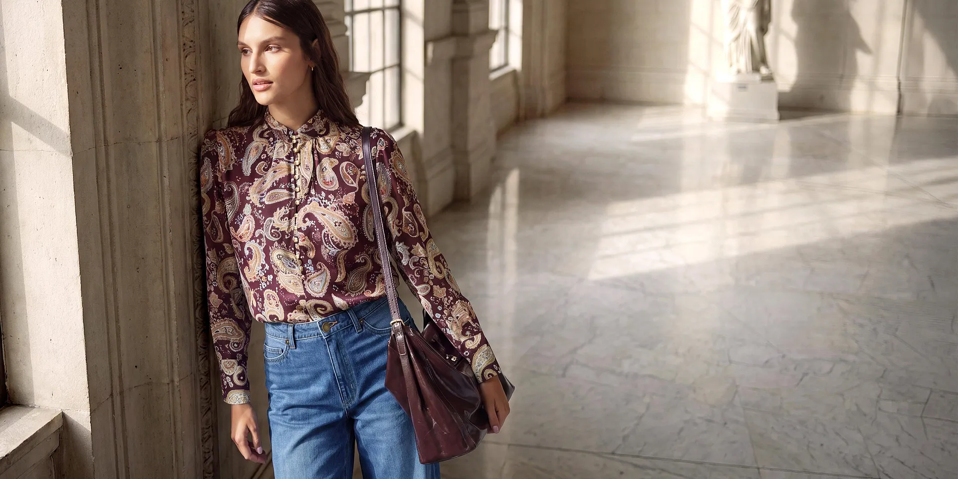 Modischer Look: Paisley-Bluse, weite Jeans, schicke Schuhe und passende Handtasche.