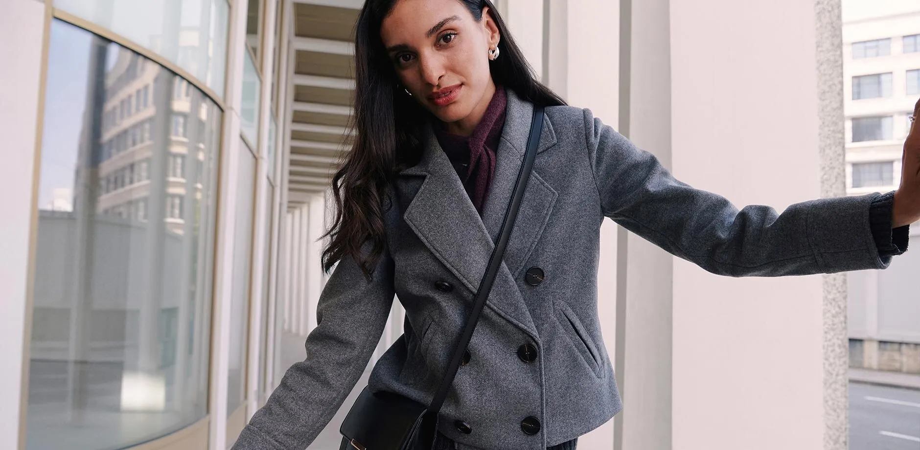 Manteau court gris, pull &agrave; col roul&eacute; fonc&eacute;.