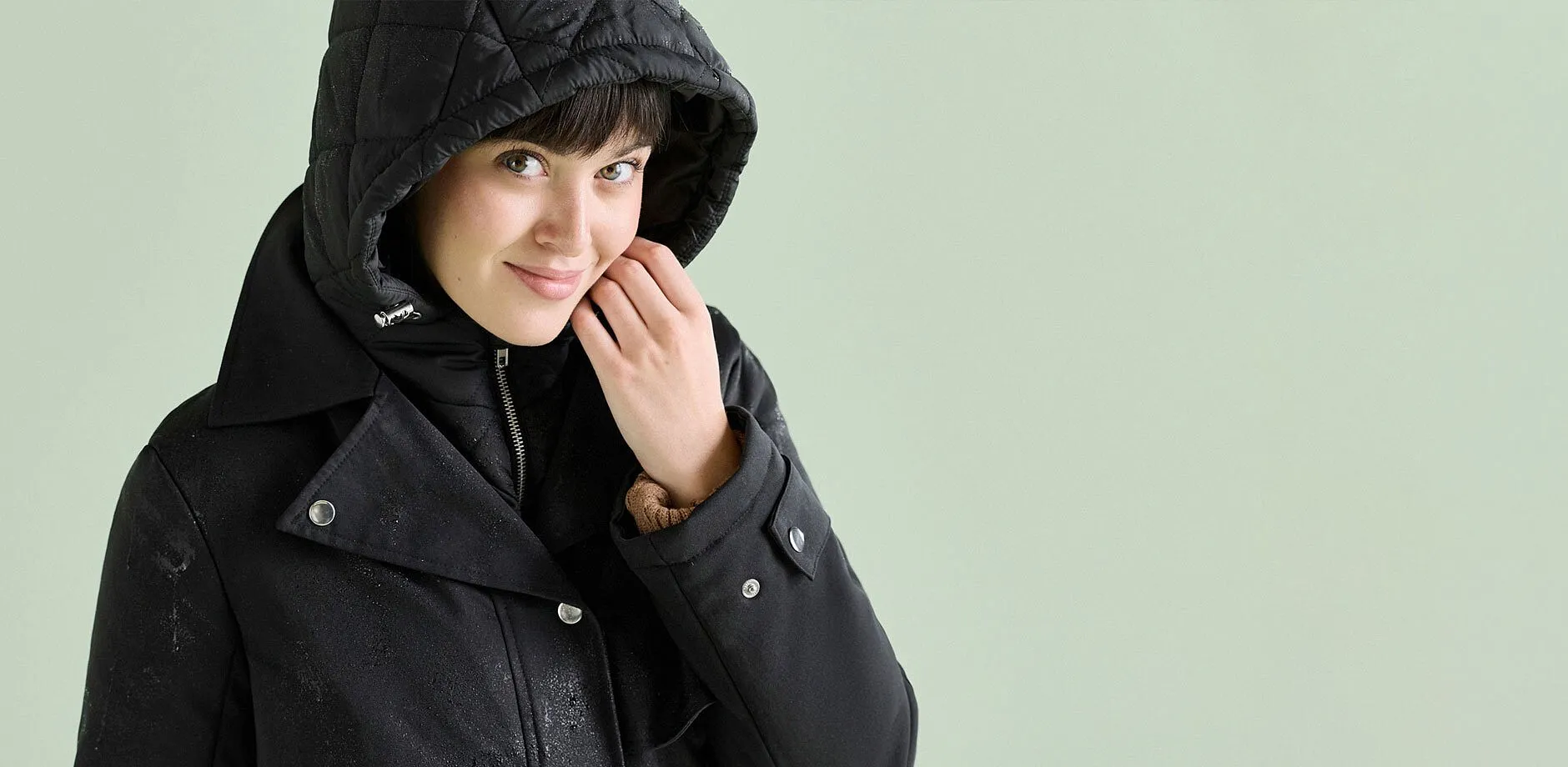 Veste double styl&eacute;e de couleur noire avec capuche matelass&eacute;e, id&eacute;ale par temps pluvieux.