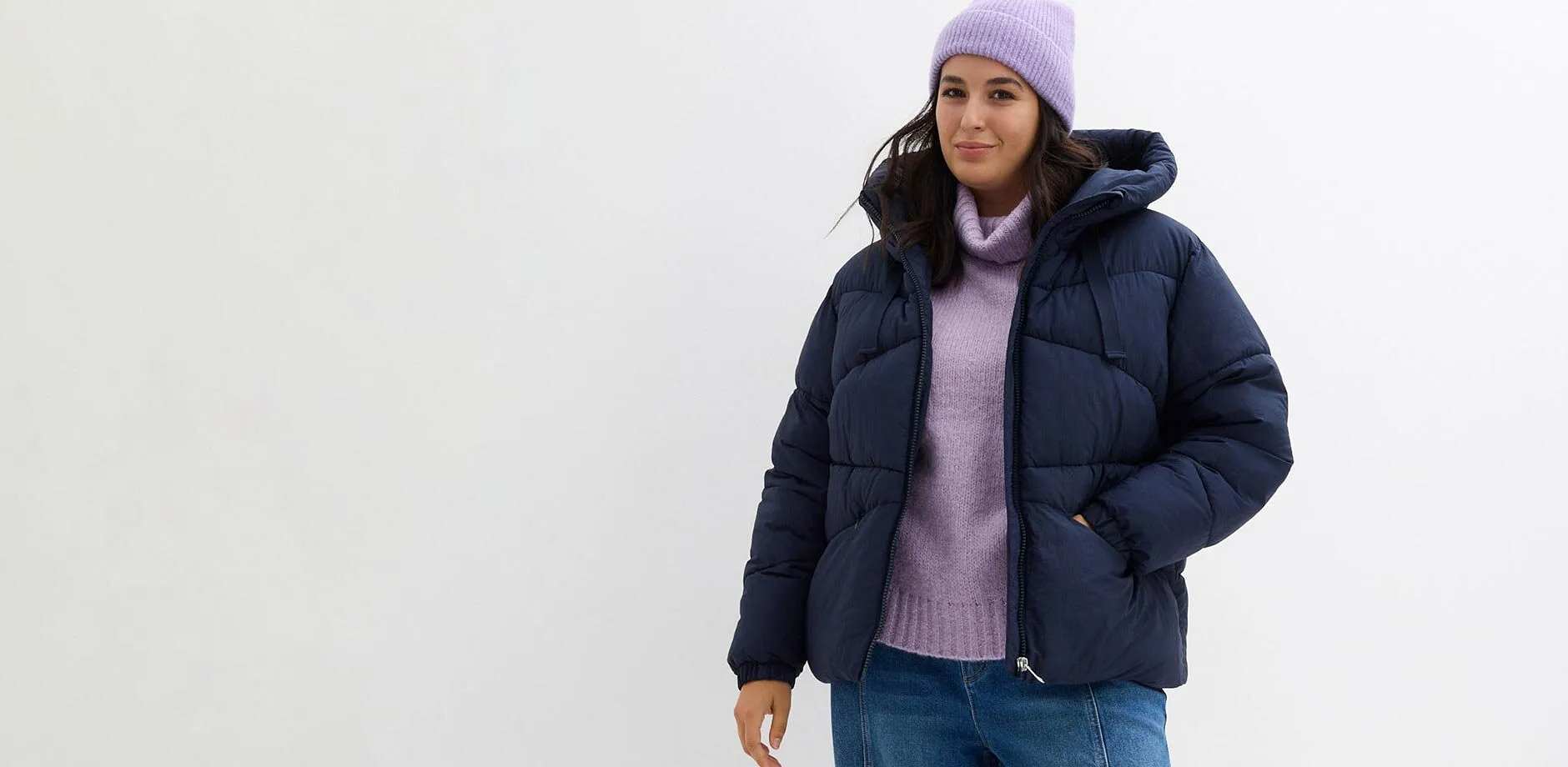 Doudoune bleu fonc&eacute;, pull &agrave; col roul&eacute; et bonnet lilas.
