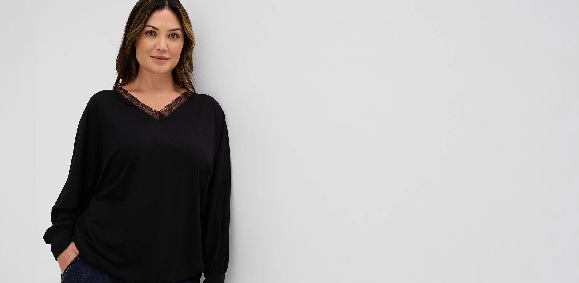 T-shirt noir moderne &agrave; manches longues avec dentelle raffin&eacute;e sur le col en V, jean fonc&eacute;.