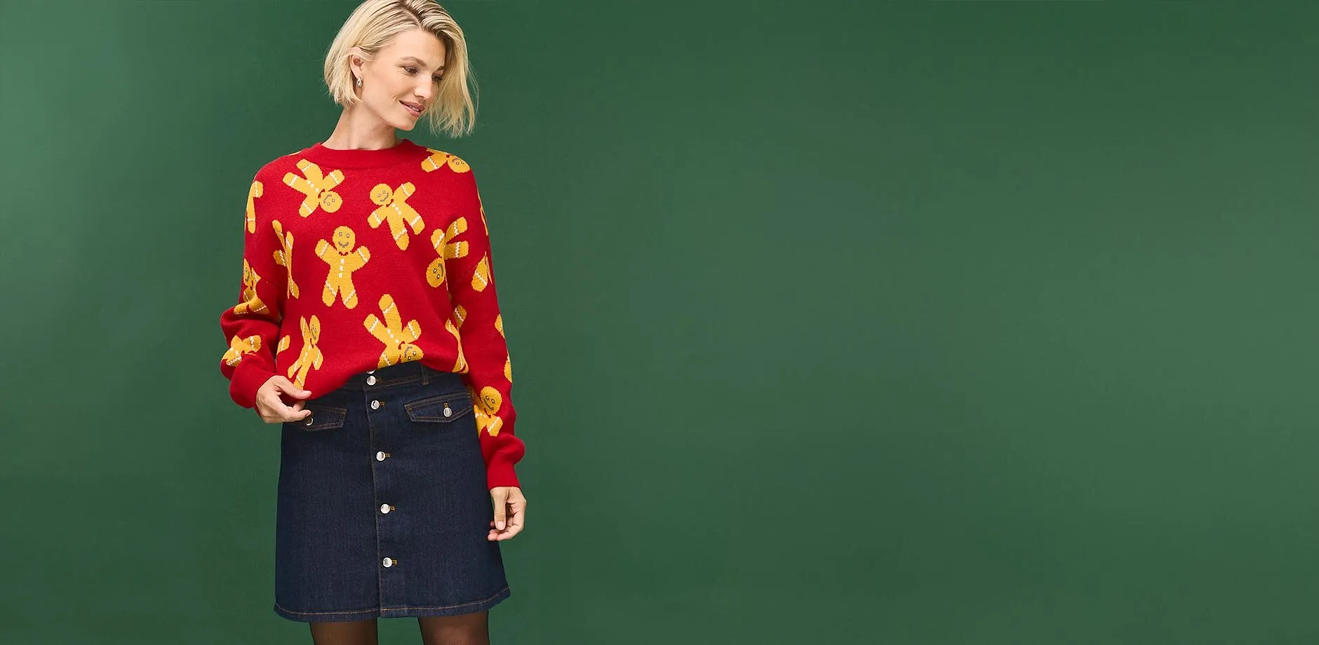 Roter Pullover mit Lebkuchenm&auml;nnern und dunkler Jeansrock mit auff&auml;lliger Knopfleiste.