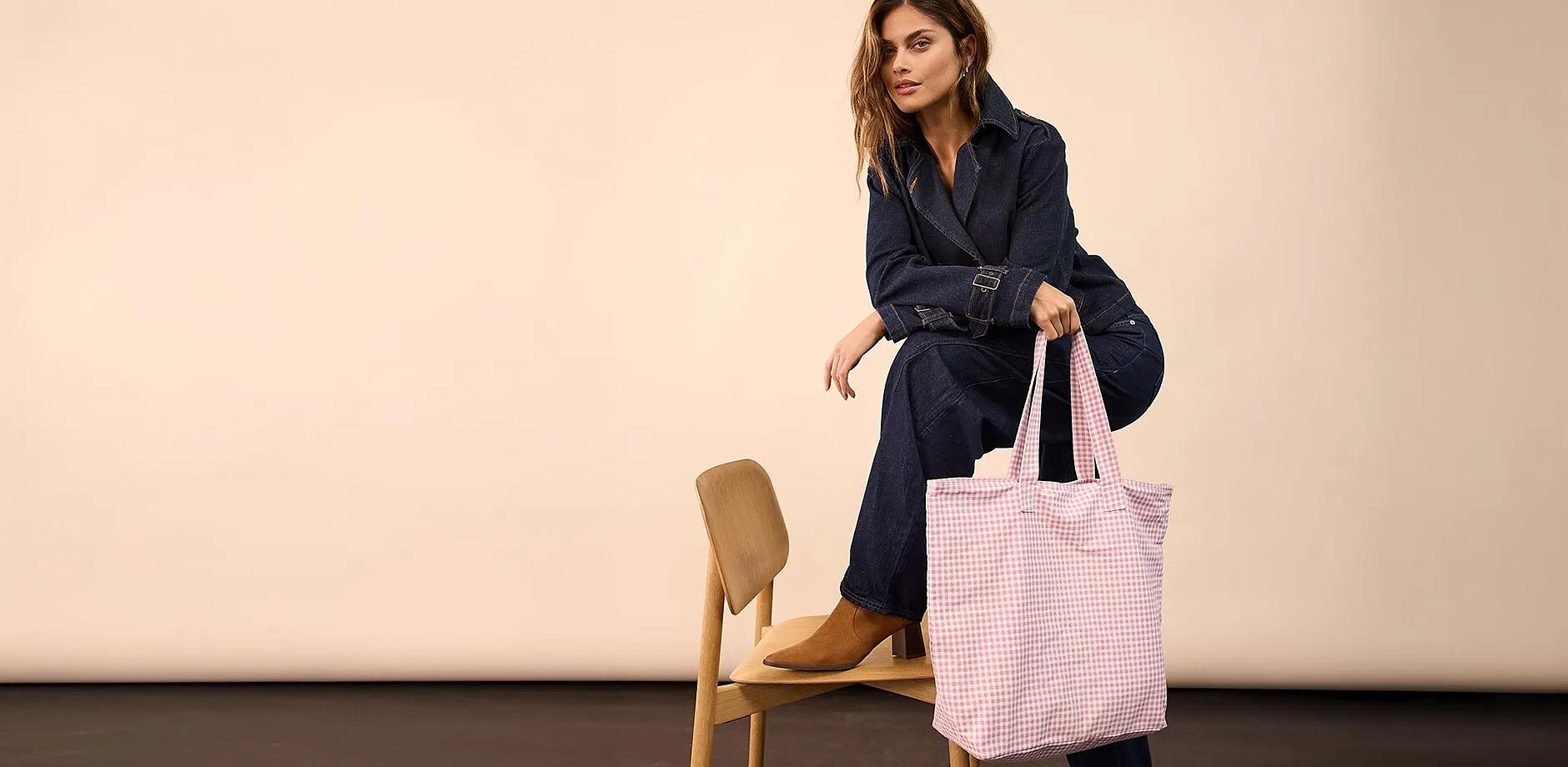 Tenue en jean, associ&eacute;e &agrave; une paire de chaussures marron et un sac rose &agrave; carreaux.