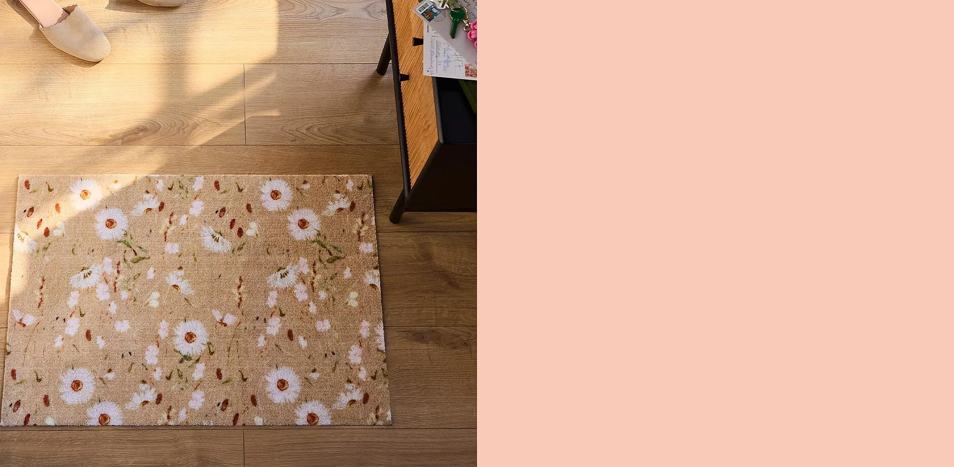 Bequeme Hausschuhe auf Holzboden neben floraler Fu&szlig;matte.