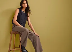 Dunkelblaues ärmelloses Top, weite braune Hose und schwarze Stiefeletten. Eleganter, lässiger Look.