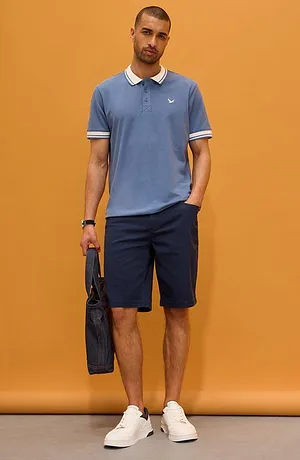 Polo bleu clair à col blanc associé à un short foncé. Un look sporty-chic pour le quotidien.