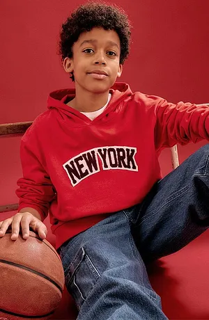 Sweat à capuche rouge avec une inscription New York et jean bleu.