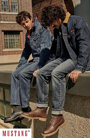 Lässiger Denim-Look: Jeansjacken und -hosen, kombiniert mit braunen Lederschuhen.