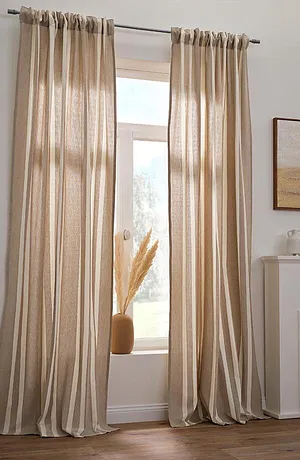 Des rideaux élégants couleur abricot habillent la fenêtre et donnent à la pièce une ambiance chaleureuse.
