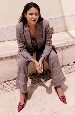 Tailleur pantalon à carreaux complété par une paire d'escarpins rouges à bout pointu.