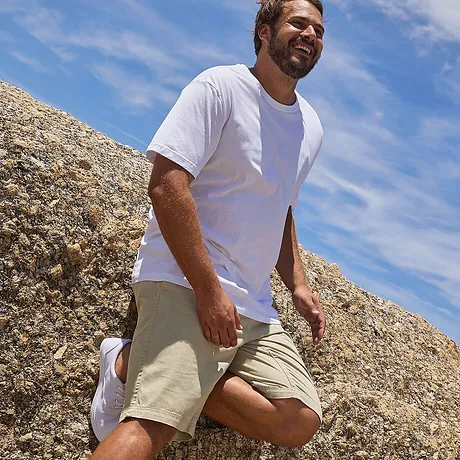Un T-shirt blanc sobre et un short beige - parfait pour une journée ensoleillée à la plage.