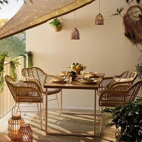 Une terrasse conviviale avec des meubles en rotin, un voile éclairé et des lanternes romantiques pour des soirées agréables.