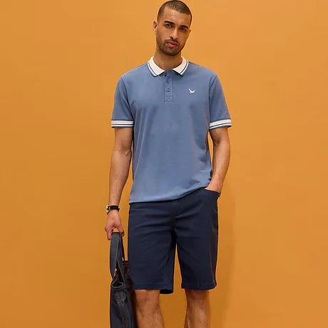 Hellblaues Poloshirt mit weißem Kragen und dunkle Hose. Sportlich-eleganter Look für den Alltag.